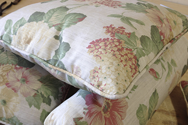 Zoom de uma almofada decorativa com acabamento em vivo no tecido floral